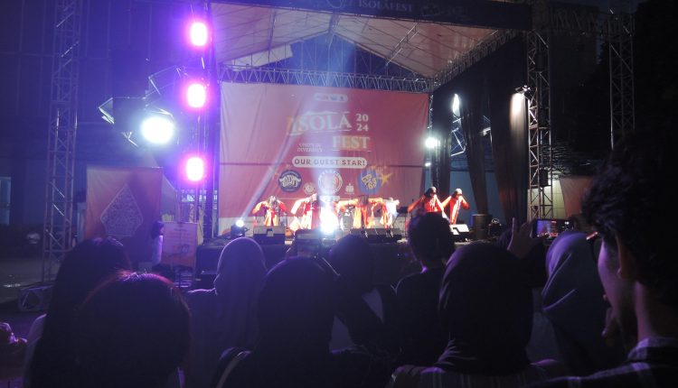Salah satu kelompok penampil sedang menari di atas panggung dalam acara Isola Fest 2024 pada Kamis (19/12) malam di depan Gymnasium UPI, Kampus Bumi Siliwangi. (Isolapos.com/Harven Kawatu).